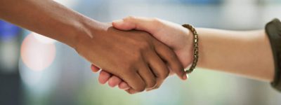 Two people shaking hands with a blurred background