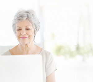 A senior woman staring at a laptop