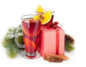 Christmas mulled wine with spices, gift box and snowy fir tree. Isolated on white background