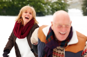 A senior couple laughing outside on a snowy day
