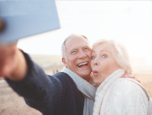 A senior couple taking a selfie together outside