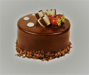 A small chocolate cake with strawberries on top