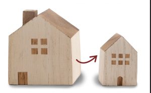 A large wooden house next to a smaller one with an arrow in between them