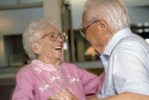 A senior couple laughing and dancing together