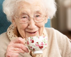 A senior woman enjoying a cup of tea and smiling