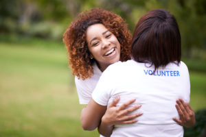 Two volunteers hugging each other and laughing