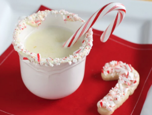 Candy cane in mug of white hot chocolate