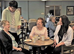 Western University students enjoying coffee with Oakcrossing Retirement residents