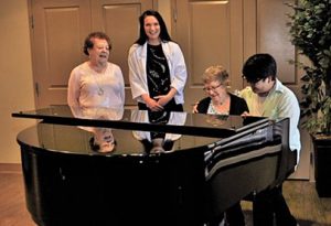 Western University students playing the piano and singing with Oakcrossing Retirement residents