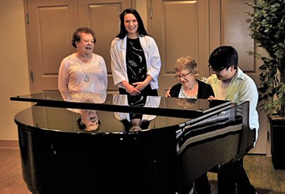 Western University students playing the piano and singing with Oakcrossing Retirement residents