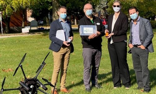 Anthony Miller (University of Waterloo), Florin Perte (Administrator, AR Goudie), Becky Agar (Hogan Pharmacy), Brent Gingerich (Chairman and CEO, peopleCare) standing outside next to drone