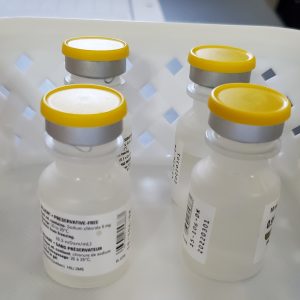 Four COVID-19 vaccine doses placed in a white basket