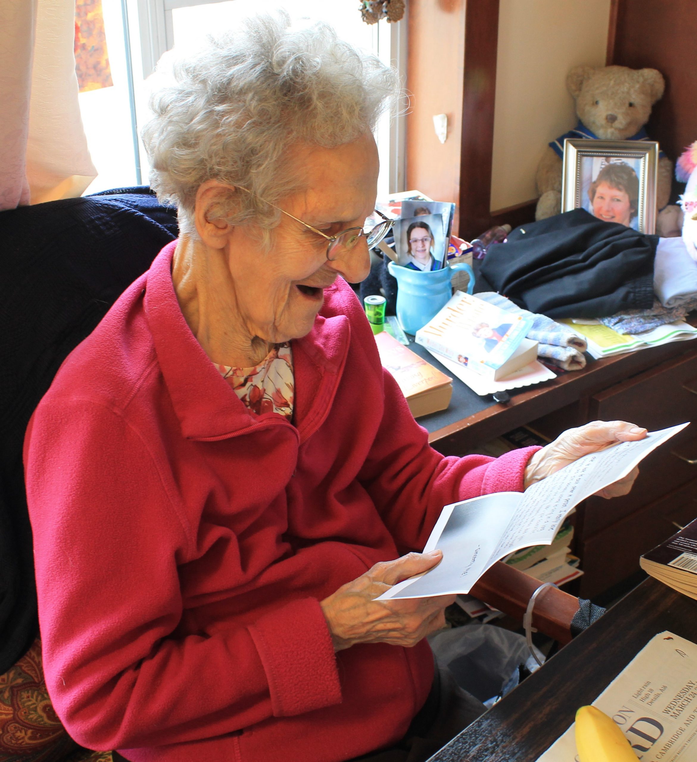 Long-term care resident reading a letter written by university students in her room
