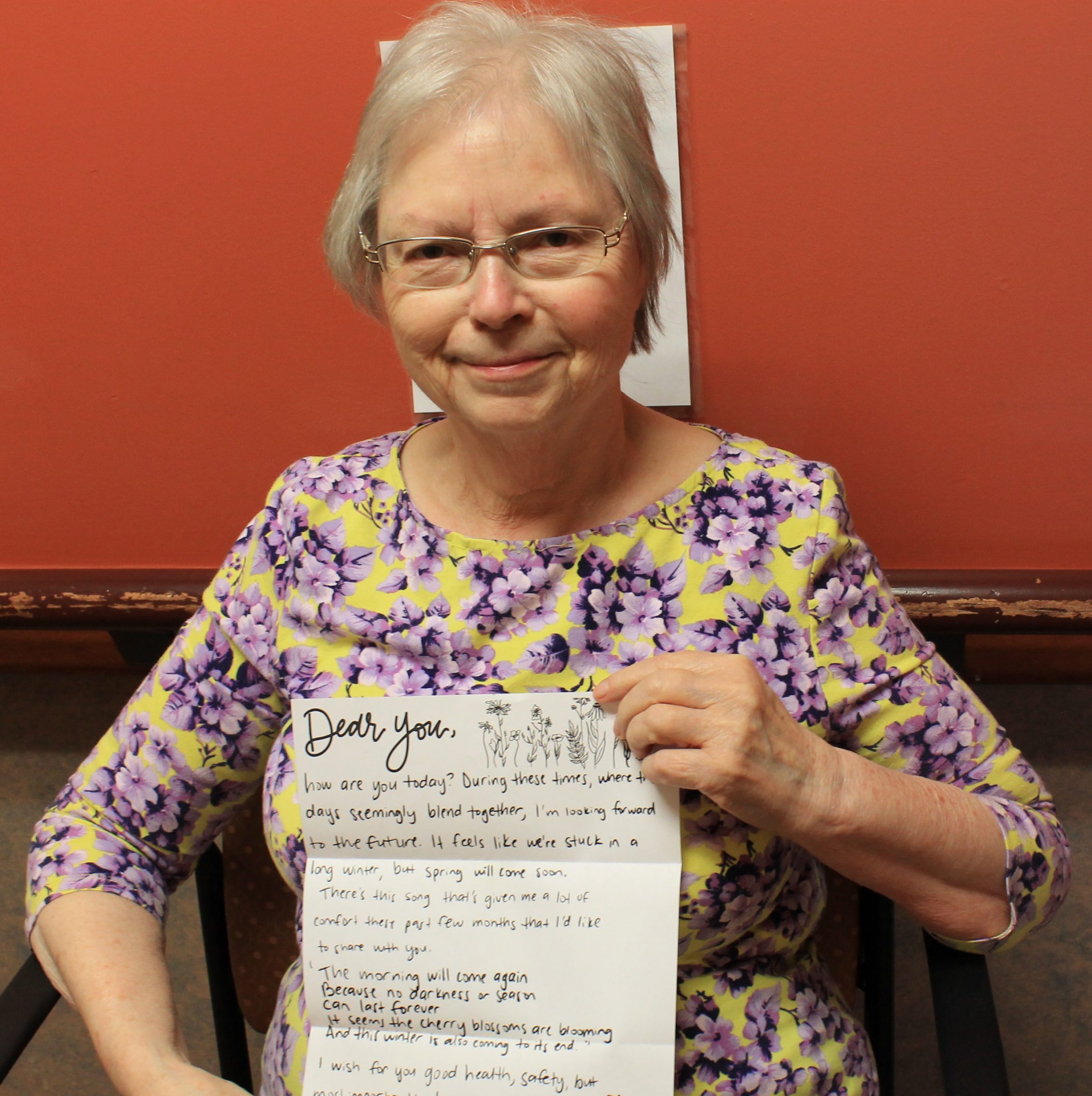 Long-term care resident holding a letter written by university student