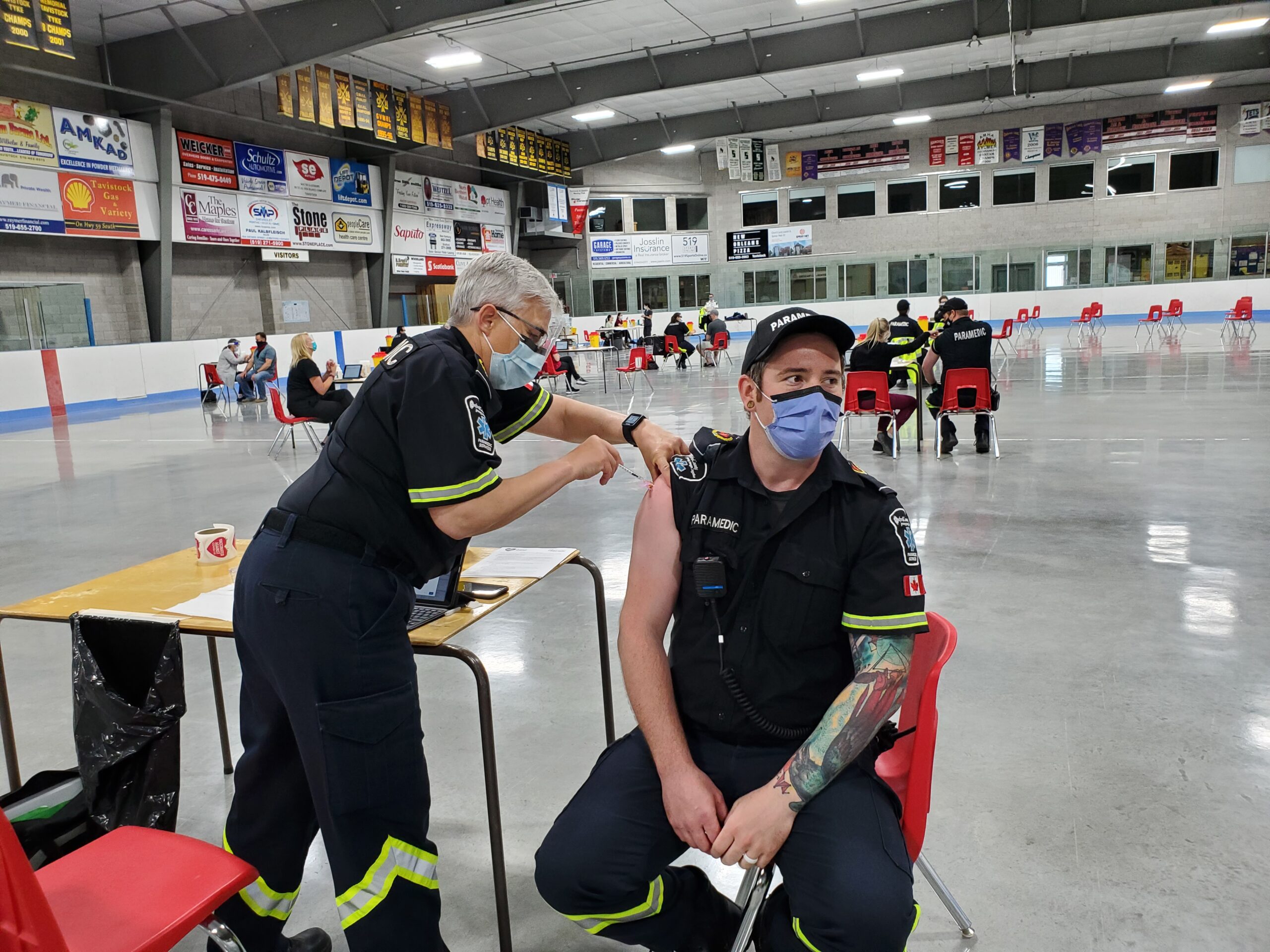 First responder Susan of the Oxford EMS gives a man his COVID vaccine at the clinic
