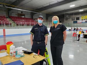 peopleCare team member and paramedic standing together at community COVID-19 vaccine clinic