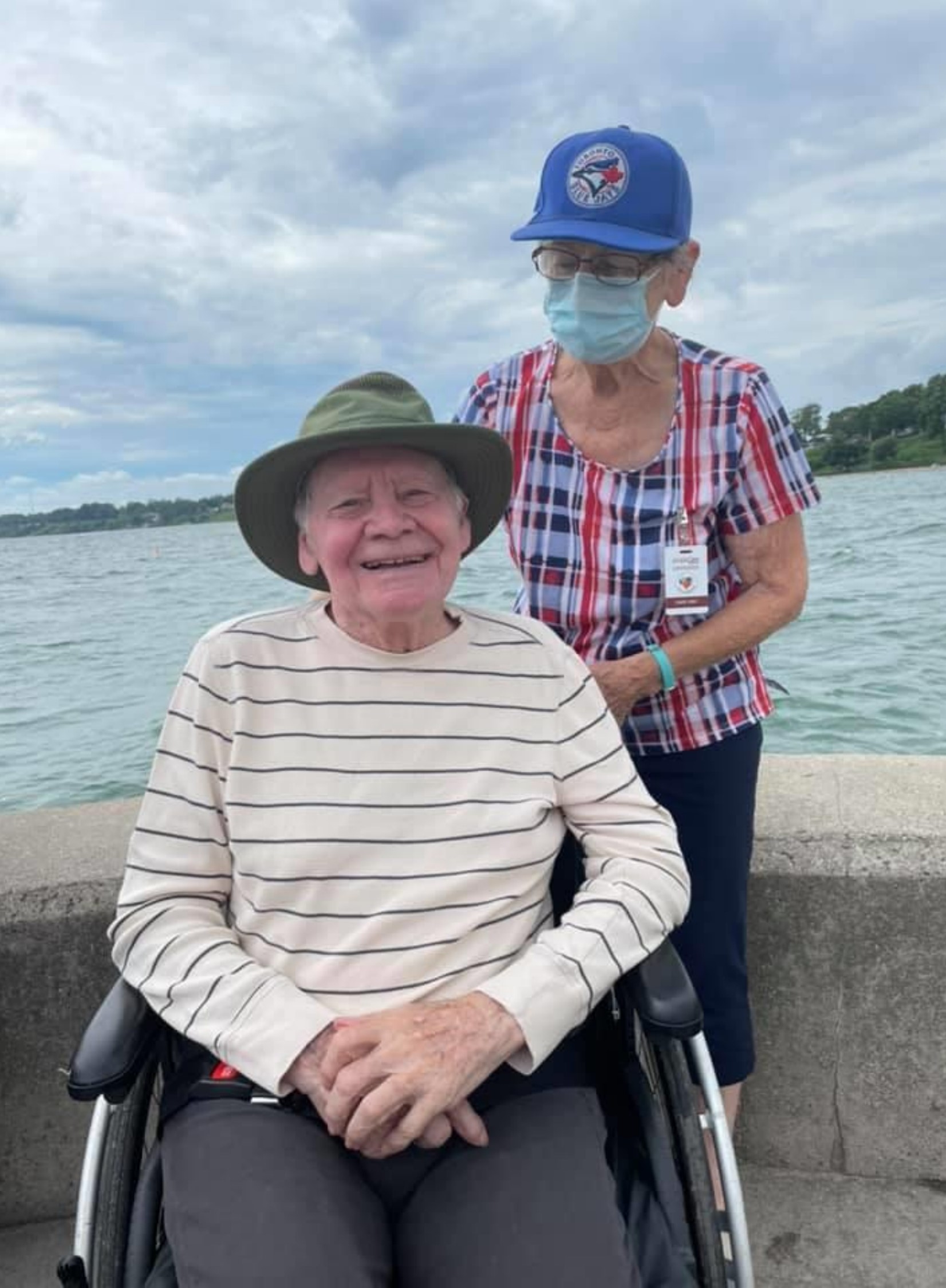 peopleCare LTC resident and designated family caregiver posing for a photo next to the lake