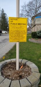A yellow sign that says "notice of public meeting."