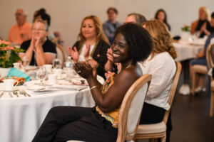 Woman at a table smiling and clapping