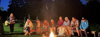 people enjoying a campfire and guitar playing