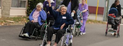 LTC resident waving a handkerchief alongside other residents on move-in day